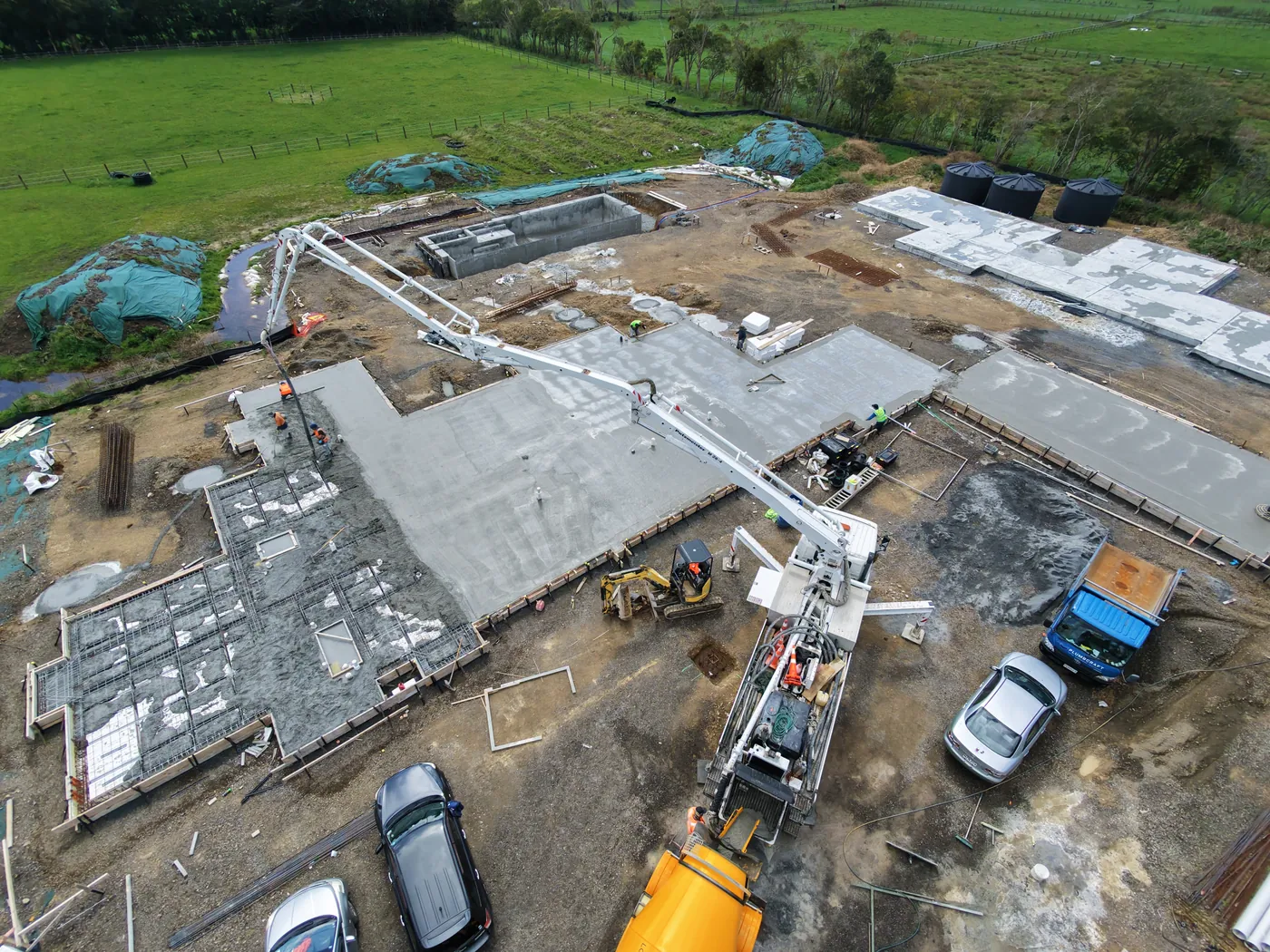 Aerial view of a GTD Construction build with a boom pump reaching across poured foundation slabs