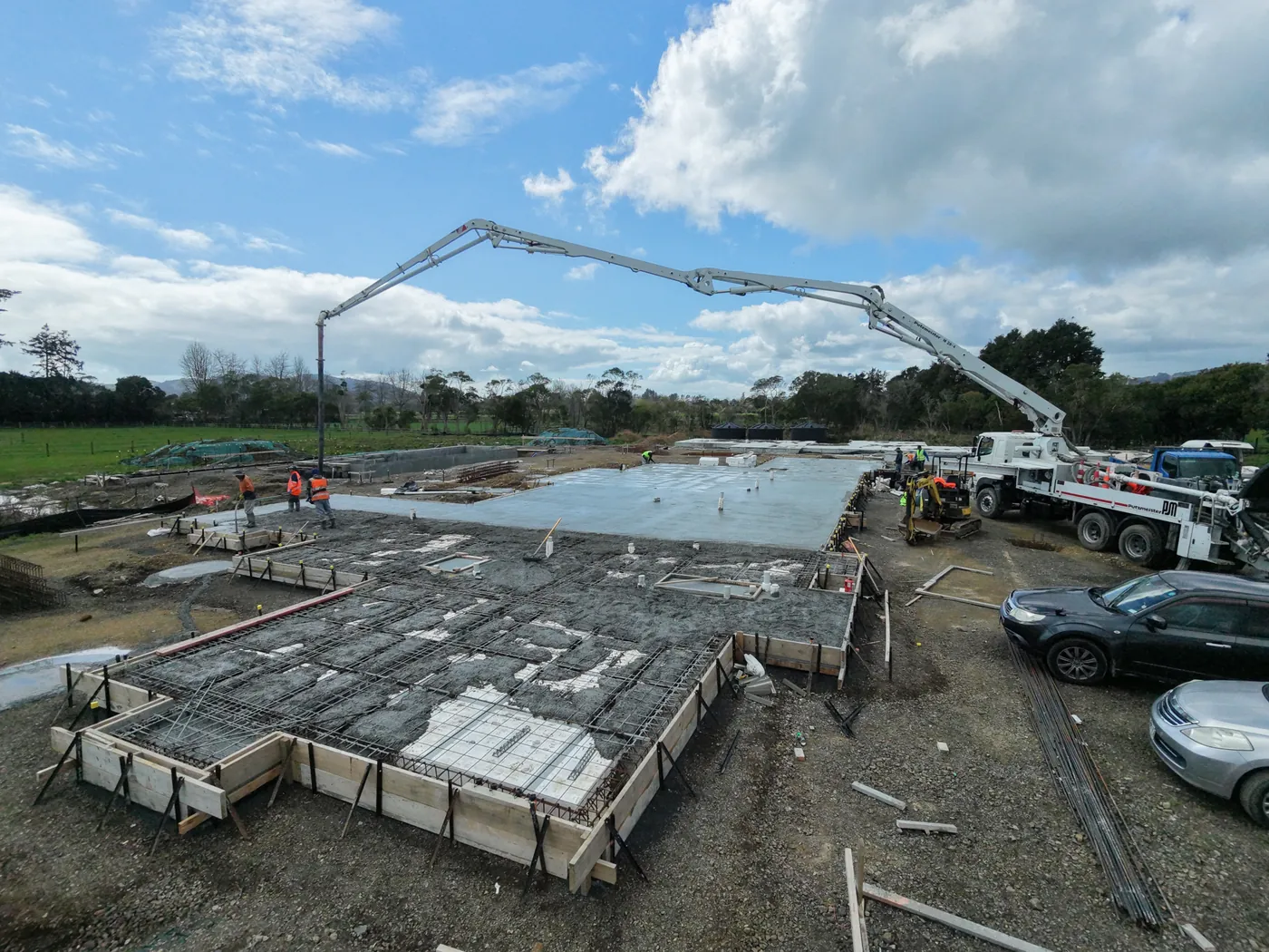Concrete boom pump placing a slab pour over steel mesh on a GTD Construction site in Auckland