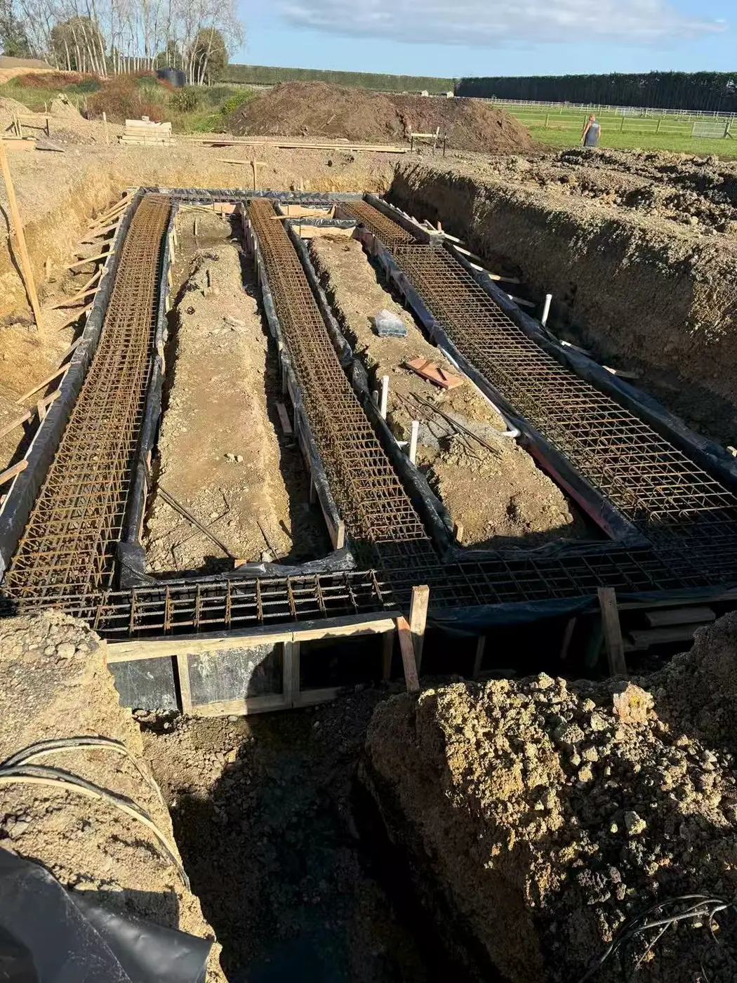Steel reinforcing cages set in footing trenches before a foundation pour